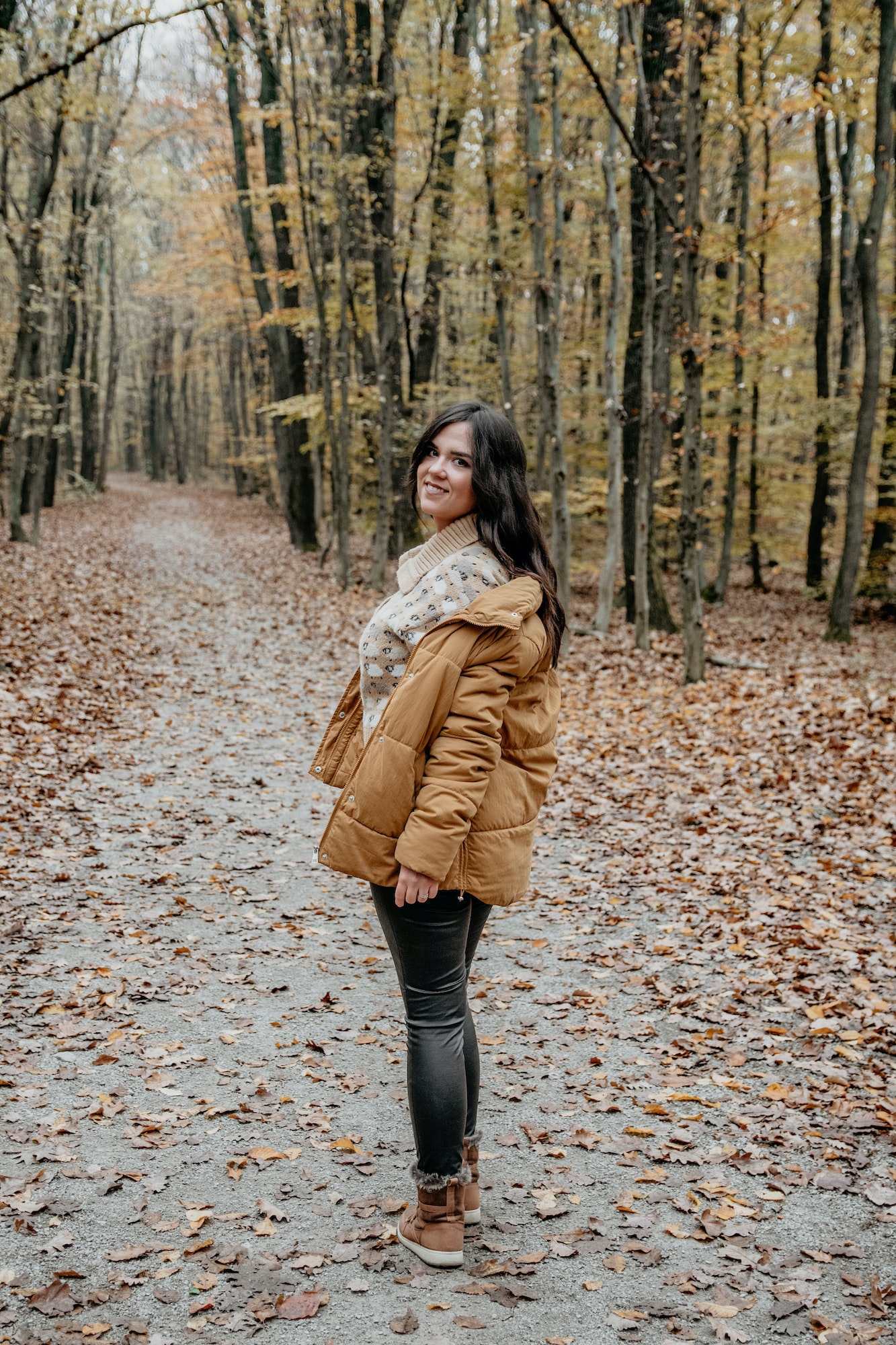 Shot of a beautiful smiling woman posing in an autumn forest